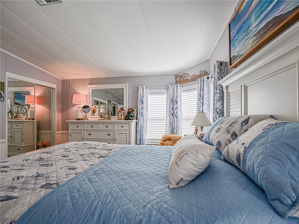 409 Avocado Drive Sebastian, FL 32976 - Photo 22 of 35 a bedroom with bed and a large mirror
