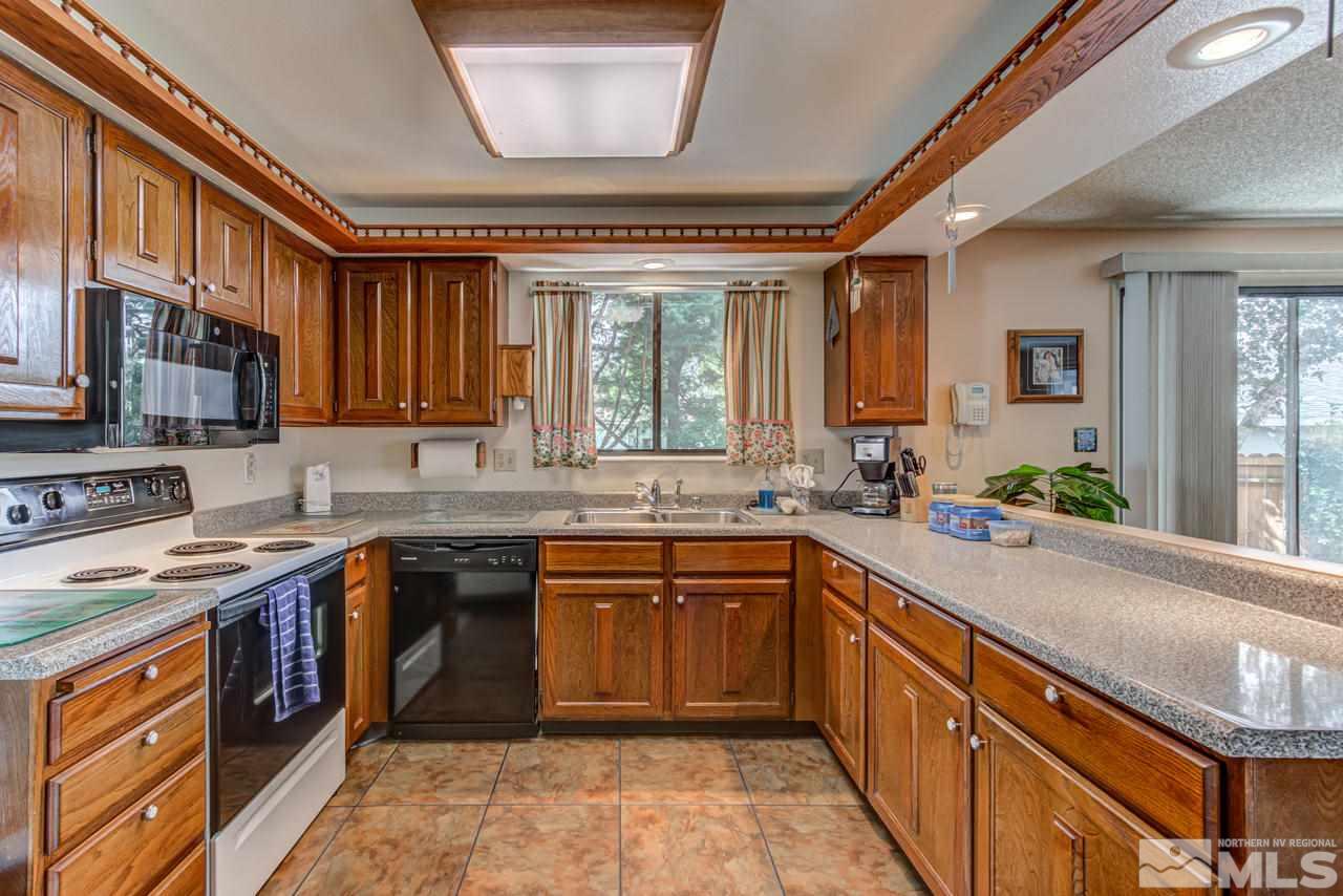 1985 Mayberry Drive Reno, NV 89509 - Photo 4 of 21 a kitchen with stainless steel appliances granite countertop wooden cabinets a sink and a stove