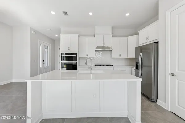 a kitchen with stainless steel appliances a refrigerator stove microwave and cabinets