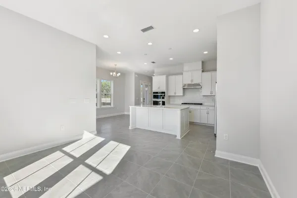 a view of kitchen with kitchen island stainless steel appliances refrigerator sink and cabinets