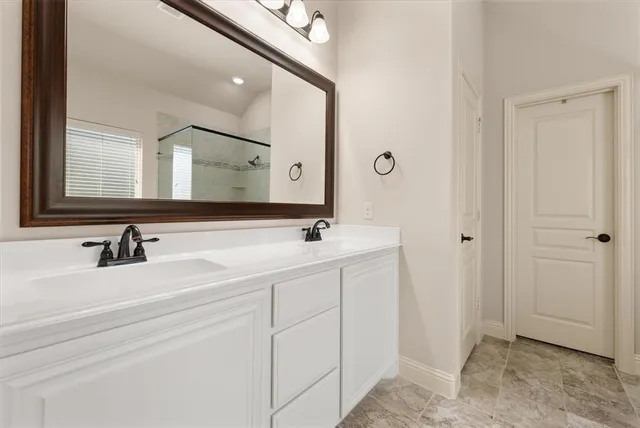 a bathroom with a double vanity sink and a mirror