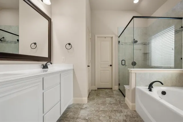 a bathroom with a tub a sink a mirror and shower