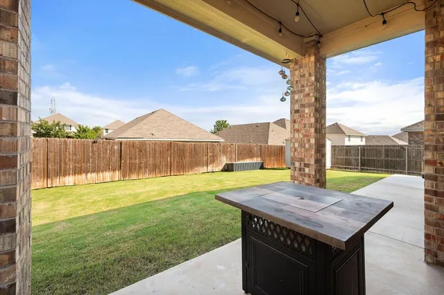 a view of a backyard with a table and chairs under an umbrella