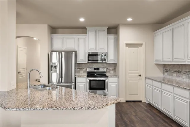 a kitchen with kitchen island a counter top space a sink appliances and cabinets
