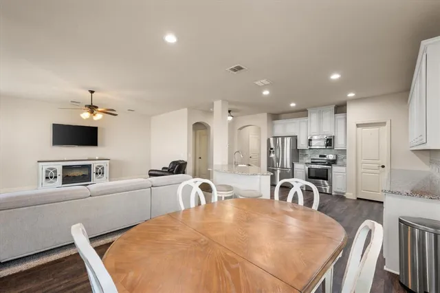 a large kitchen with kitchen island a dining table chairs and a refrigerator