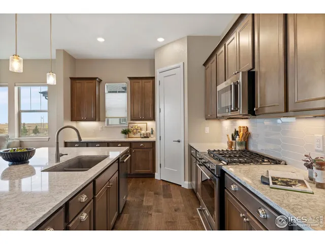 a kitchen with granite countertop stainless steel appliances a sink stove top oven and cabinets