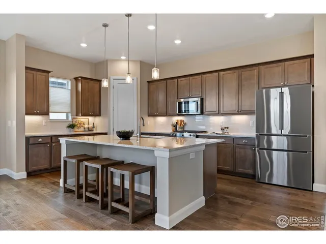 a kitchen with refrigerator a sink and chairs