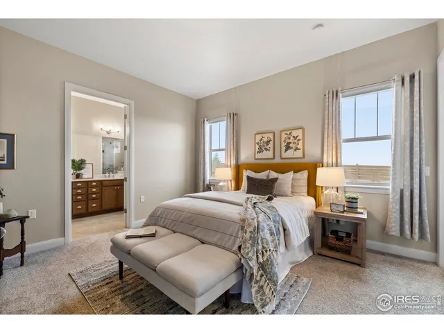 a bedroom with a bed a couch and a view of kitchen