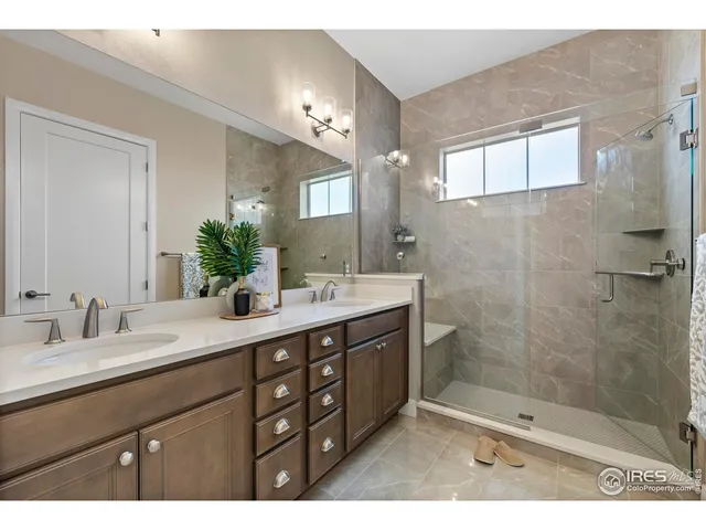 a bathroom with a double vanity sink mirror and shower