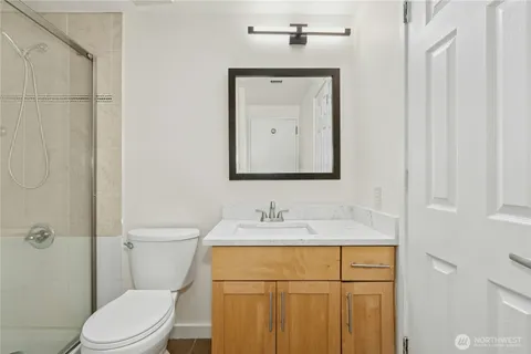 a bathroom with a toilet sink vanity and mirror