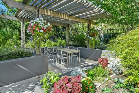a patio with table and chairs and potted plants