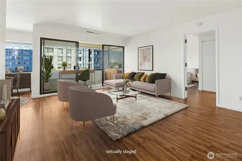 a living room with furniture wooden floor and a large window
