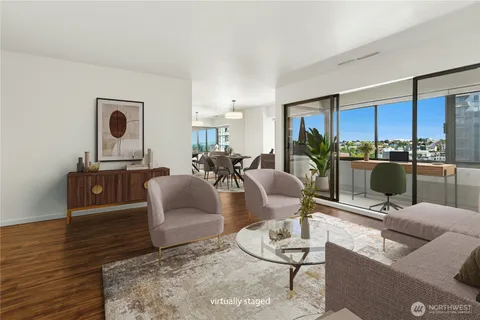 a living room with furniture a rug and a floor to ceiling window