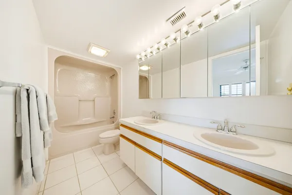 a bathroom with a sink a toilet and a large mirror