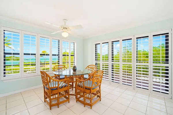 a dining room with furniture and large windows