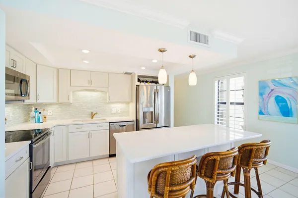 a kitchen with stainless steel appliances kitchen island granite countertop a sink and cabinets