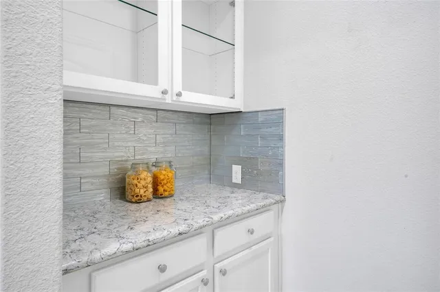 a kitchen with granite countertop a sink and cabinets