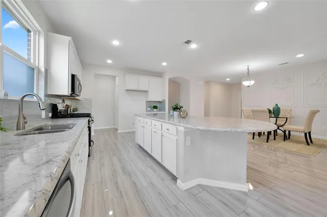 a large kitchen with kitchen island a island a sink a stove and a center island