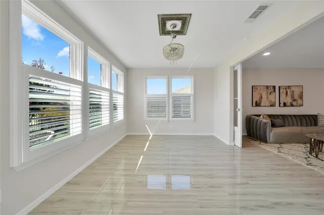 a view of an empty room with a window and a kitchen