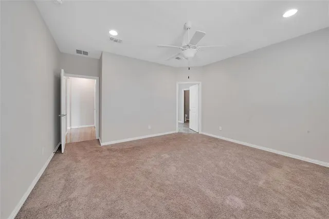 an empty room with fan and entrance