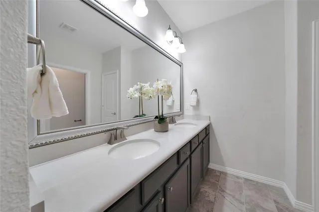 a bathroom with a granite countertop sink a large mirror and a shower