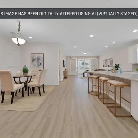a living room with furniture a wooden floor and kitchen view