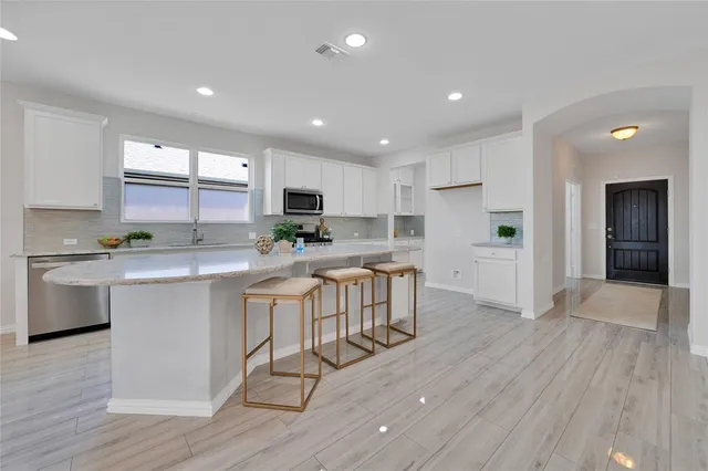 a kitchen with white cabinets and appliances