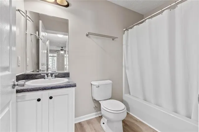 a bathroom with a granite countertop sink toilet and a mirror