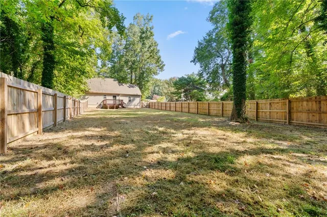 a view of a yard with wooden fence