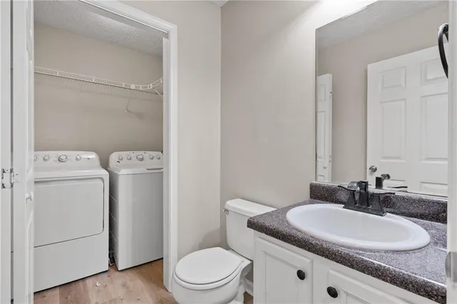 a bathroom with a granite countertop toilet sink and mirror