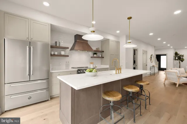 a large kitchen with kitchen island a sink a stove a dining table and chairs