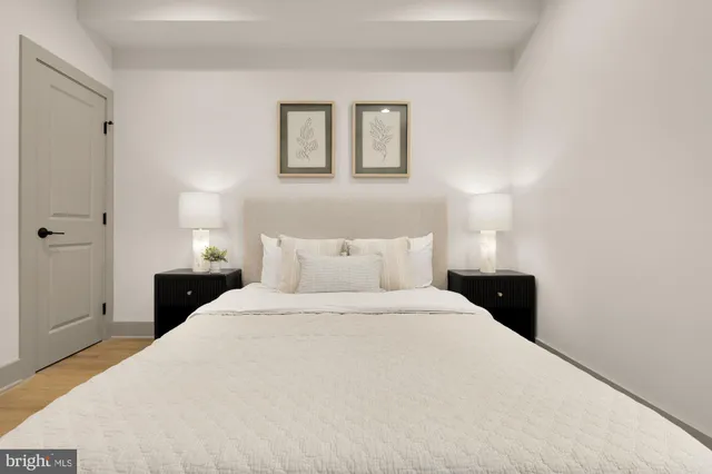 a view of a hallway with wooden floor and a door