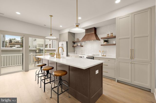 a kitchen with stainless steel appliances kitchen island a stove a refrigerator and a sink