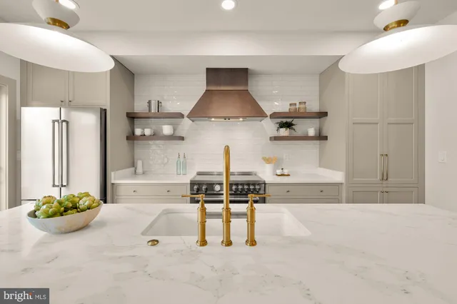 a kitchen with stainless steel appliances a sink a stove a refrigerator and island