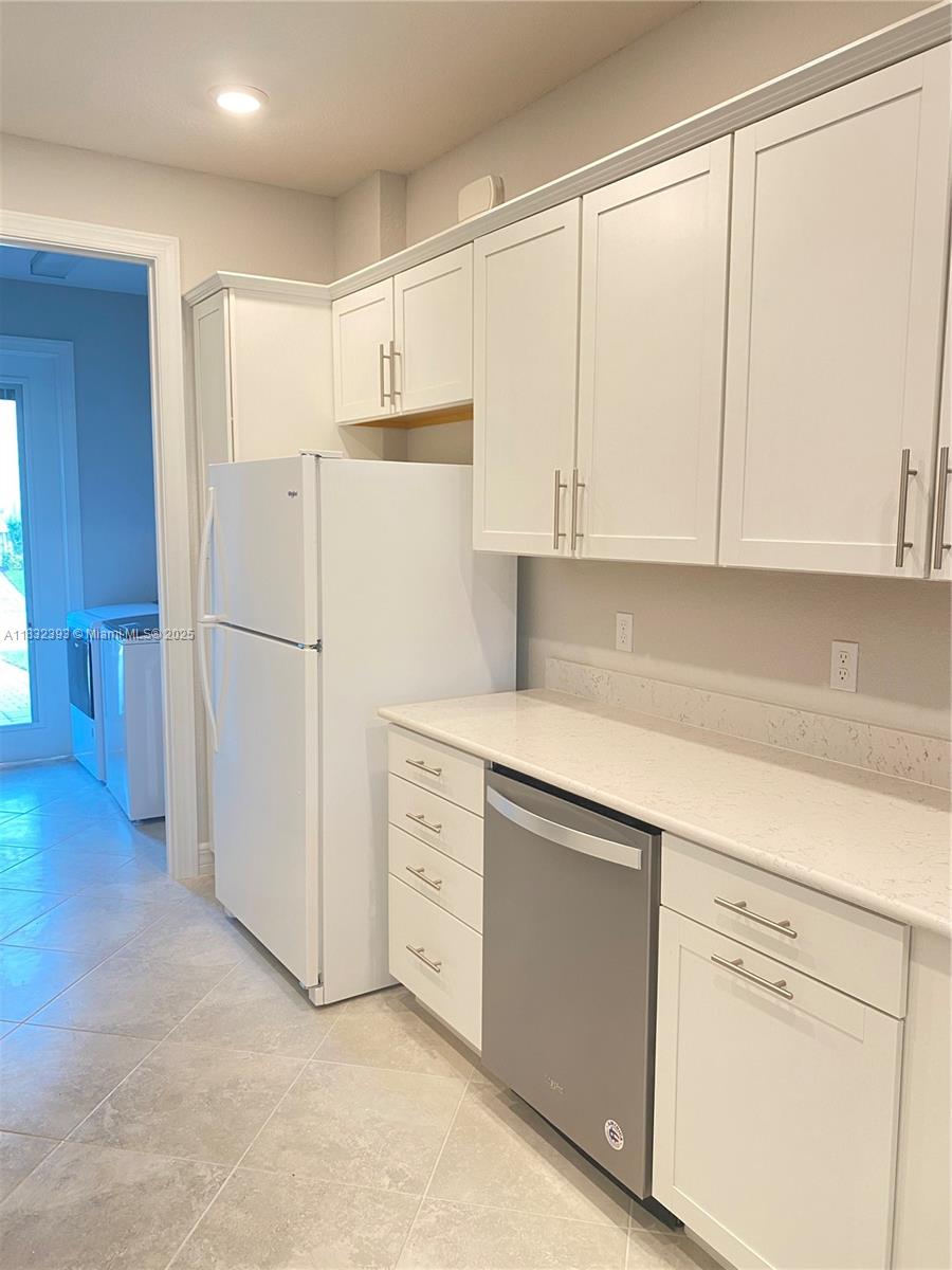 1280 Eucalyptus Drive, Unit 4 Hollywood, FL 33021 - Photo 23 of 36 a kitchen with cabinets and a refrigerator
