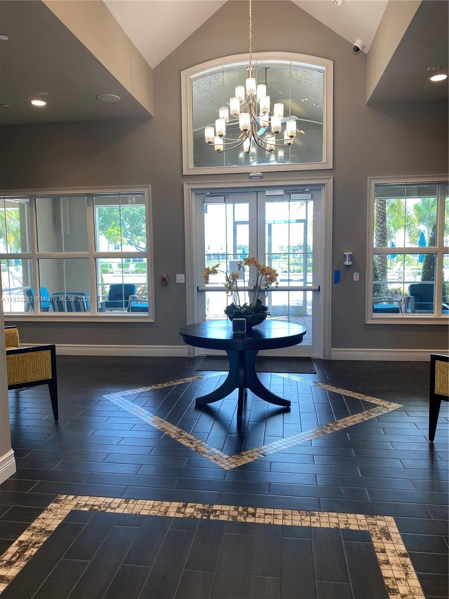 1280 Eucalyptus Drive, Unit 4 Hollywood, FL 33021 - Photo 26 of 36 a living room with dining table a chandelier and a large window