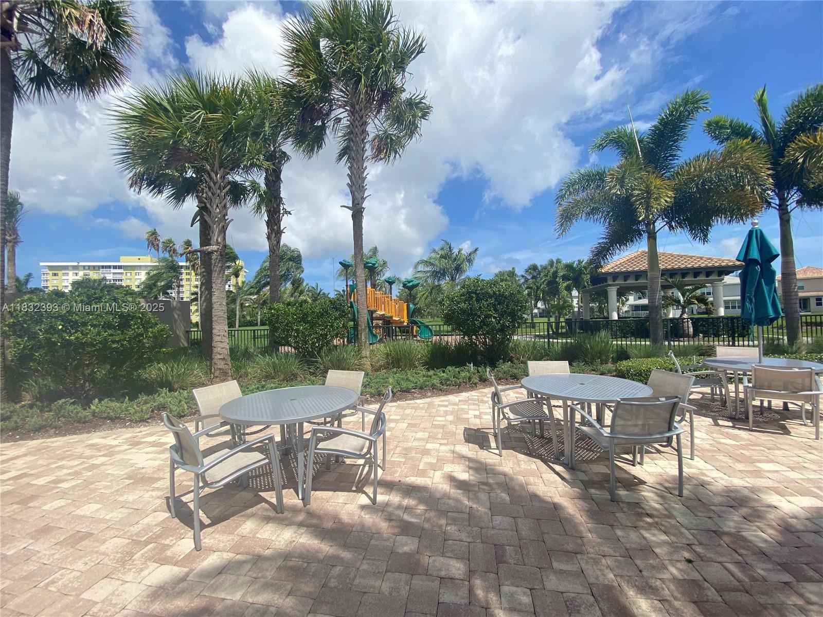 1280 Eucalyptus Drive, Unit 4 Hollywood, FL 33021 - Photo 30 of 36 a view of a patio with a table and chairs under an umbrella