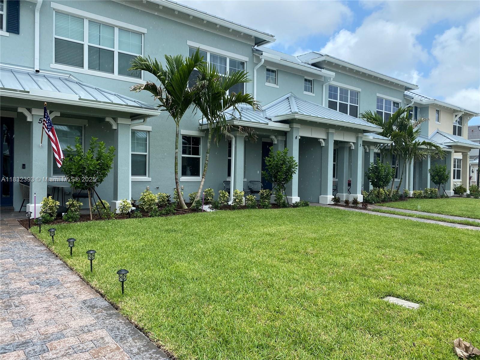 1280 Eucalyptus Drive, Unit 4 Hollywood, FL 33021 - Photo 32 of 36 a view of a house with brick walls and a yard with potted plants
