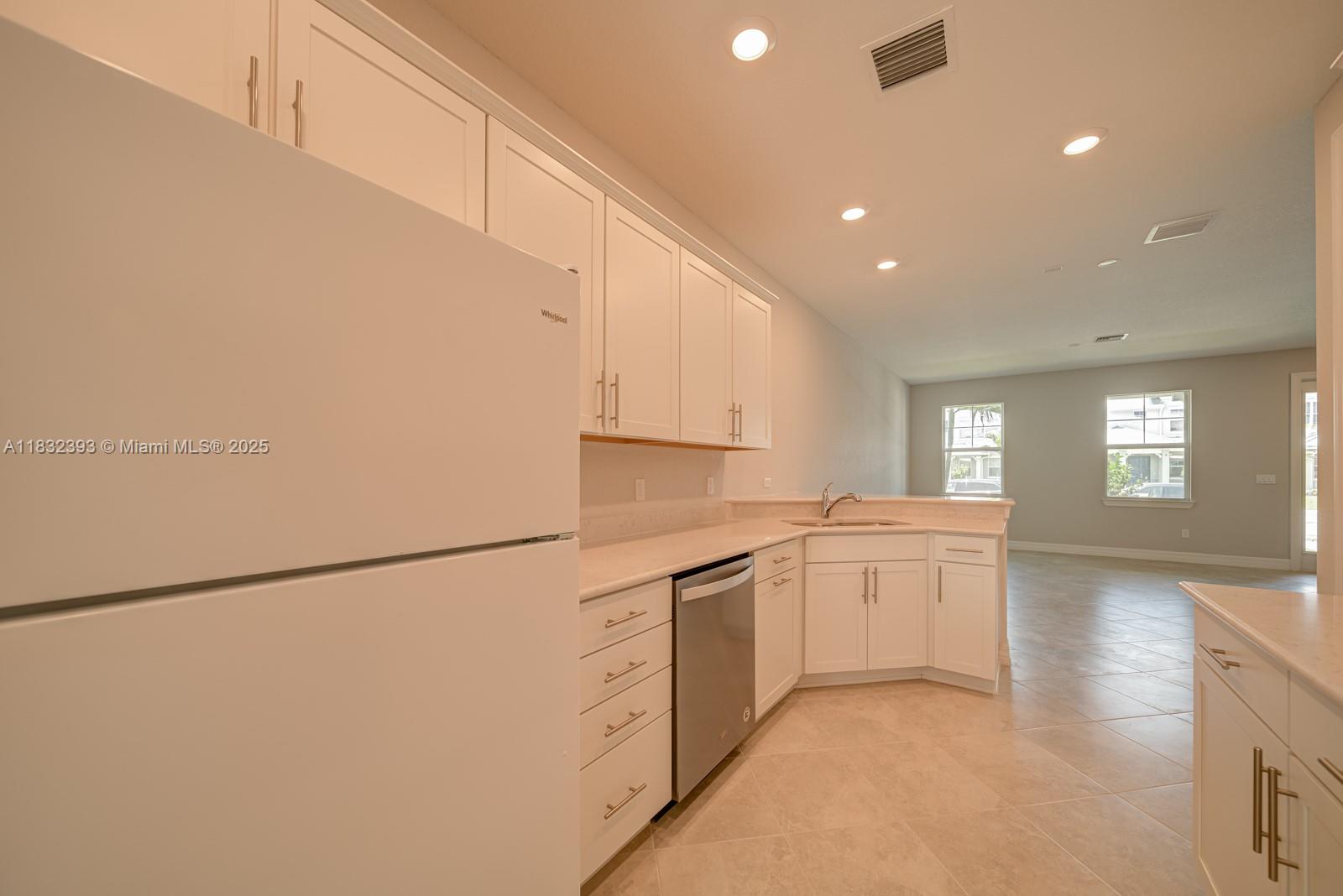 1280 Eucalyptus Drive, Unit 4 Hollywood, FL 33021 - Photo 4 of 36 a kitchen with white cabinets and white appliances