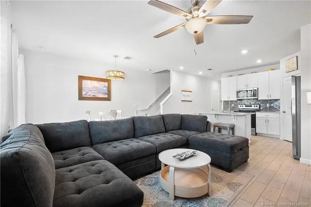 a living room with furniture and a chandelier