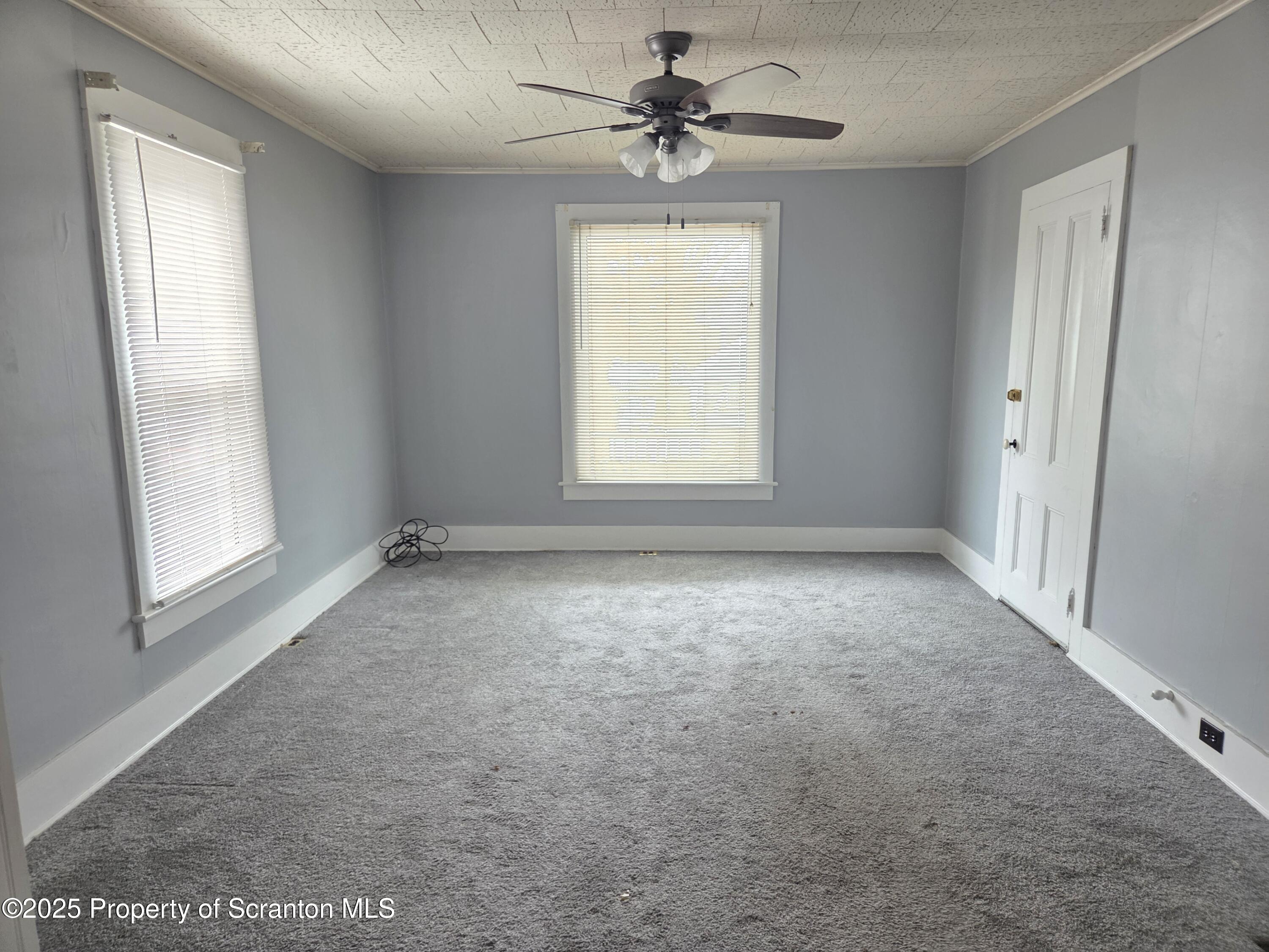 5 East Harrison Street Tunkhannock, PA 18657 - Photo 22 of 25 an empty room with windows and chandelier fan