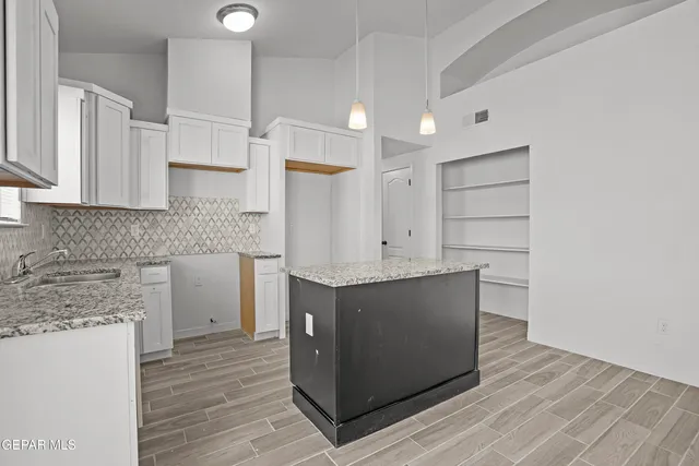 a kitchen with stainless steel appliances cabinets and wooden floor