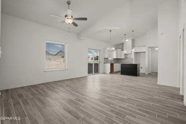 a view of kitchen and empty room with wooden floor
