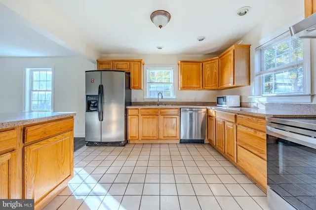 a kitchen with stainless steel appliances granite countertop a stove a sink dishwasher and a refrigerator