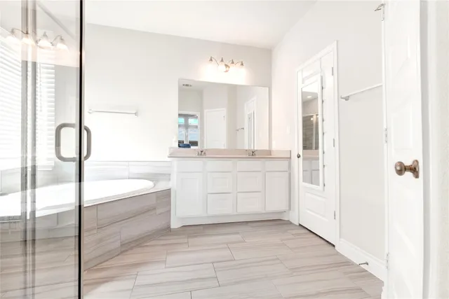 a bathroom with a bathtub sink and mirror