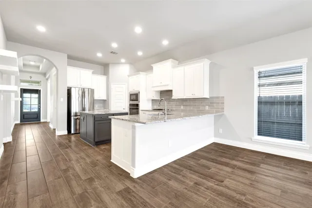 a kitchen with stainless steel appliances granite countertop a refrigerator and a sink