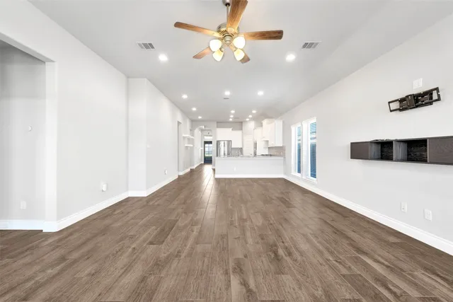 a view of an empty room with wooden floor