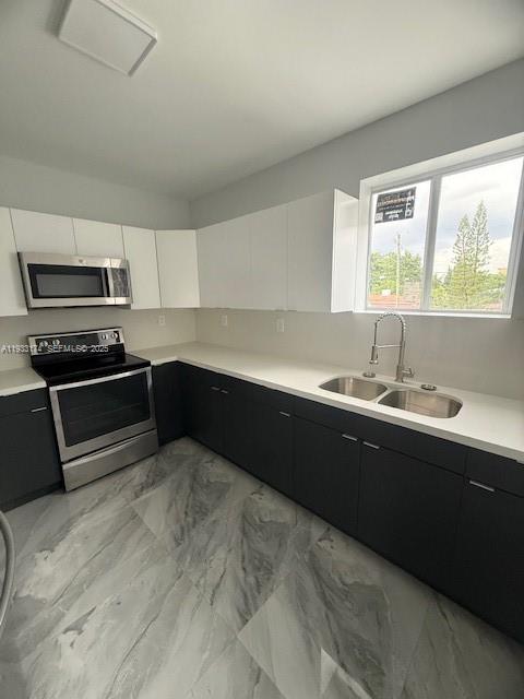 166 Northeast 70th Street, Unit 2 Miami, FL 33138 - Photo 8 of 15 a kitchen with wooden cabinets a sink and a stove