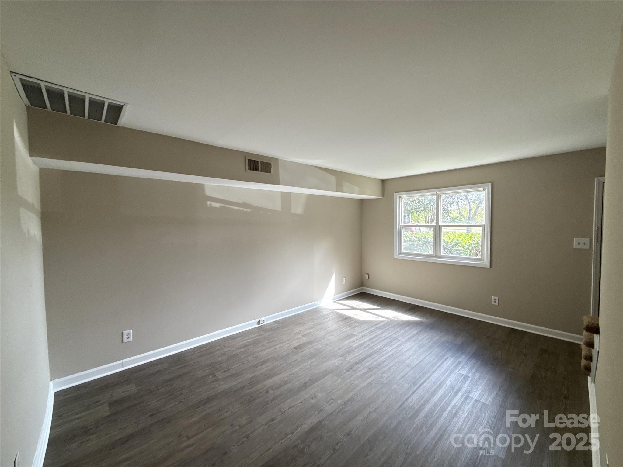 1613 North Sharon Amity Road, Unit G Charlotte, NC 28205 - Photo 2 of 12 an empty room with wooden floor and windows