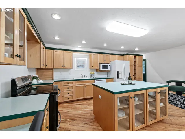 a kitchen with stainless steel appliances granite countertop a stove a sink and a refrigerator